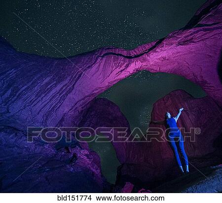 "Woman standing in illuminated rocks at night in Arches National Park, Moab, Utah, United States" View Large Photo Image Picture - "Woman standing in illuminated rocks at night in Arches National Park, Moab, Utah, United States". Fotosearch