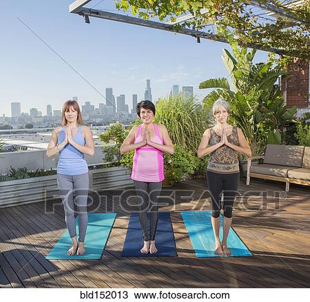 Women practicing yoga together on urban rooftop View Large Photo Image Stock Image - Women practicing yoga together on urban rooftop. Fotosearch