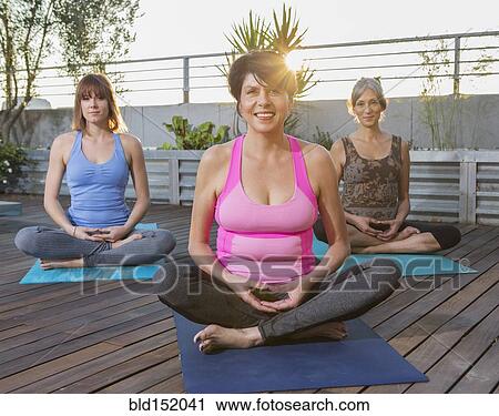 Women sitting on yoga mats on rooftop View Large Photo Image Stock Image - Women sitting on yoga mats on rooftop. Fotosearch