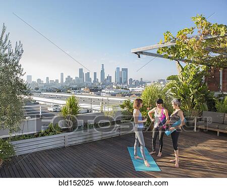 Women talking after practicing yoga on urban rooftop View Large Photo Image Stock Photography - Women talking after practicing yoga on urban rooftop. Fotosearch