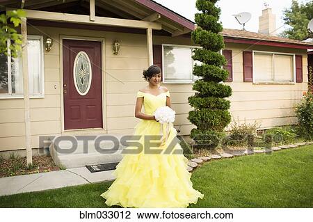 Stock Image - Hispanic girl wearing quinceanera dress in front lawn. Fotosearch