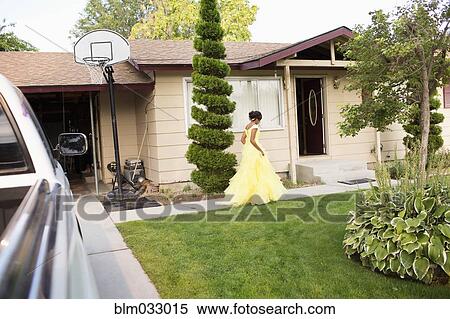 Stock Photography - Hispanic girl wearing quinceanera dress in front lawn. Fotosearch