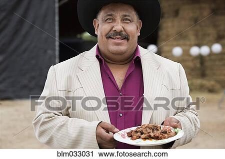 Stock Image - Hispanic man wearing cowboy hat at quinceanera. Fotosearch