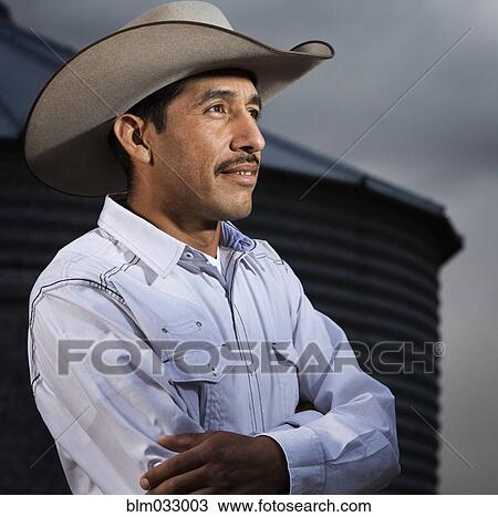 Stock Image - Hispanic man wearing cowboy hat. Fotosearch
