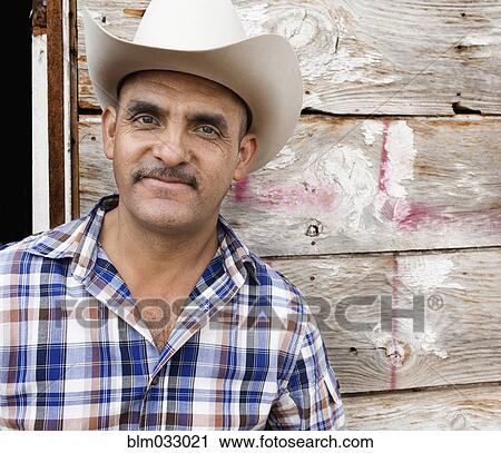 Stock Image - Hispanic man wearing cowboy hat. Fotosearch