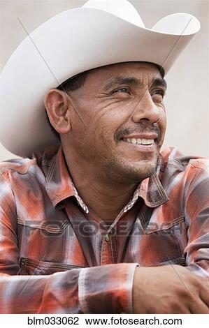 Stock Image - Hispanic man wearing cowboy hat. Fotosearch
