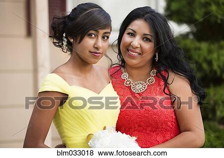 Stock Photo - Hispanic mother celebrating quinceanera with daughter. Fotosearch