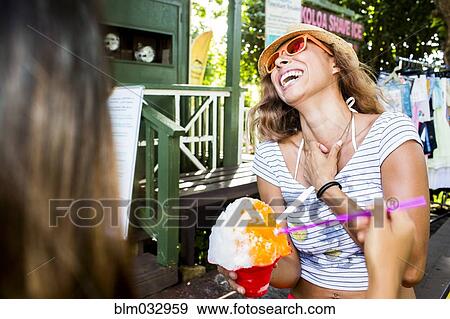 Laughing woman eating shaved ice View Large Photo Image Stock Photo - Laughing woman eating shaved ice. Fotosearch