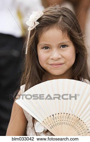Smiling Hispanic girl holding fan View Large Photo Image Stock Image - Smiling Hispanic girl holding fan. Fotosearch