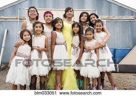 Stock Image - Women in Hispanic family celebrating quinceanera. Fotosearch
