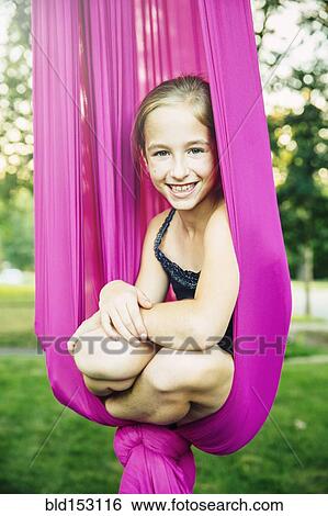 Acrobatic Caucasian girl sitting in hanging fabric View Large Photo Image Stock Photograph - Acrobatic Caucasian girl sitting in hanging fabric. Fotosearch