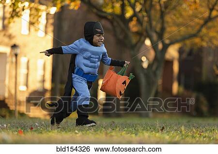 Stock Photograph - African American boy trick-or-treating on Halloween. Fotosearch