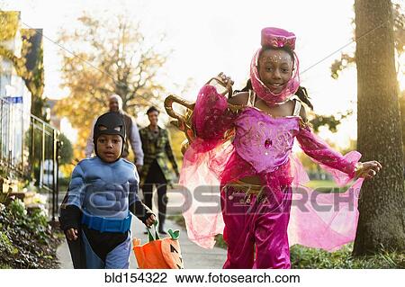 Stock Image - African American children trick-or-treating on Halloween. Fotosearch