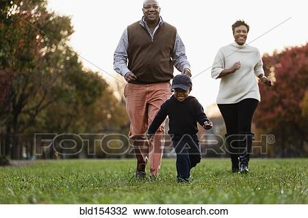 Stock Image - African American family playing in park. Fotosearch