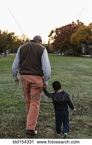 Stock Image - African American father and son walking in park. Fotosearch