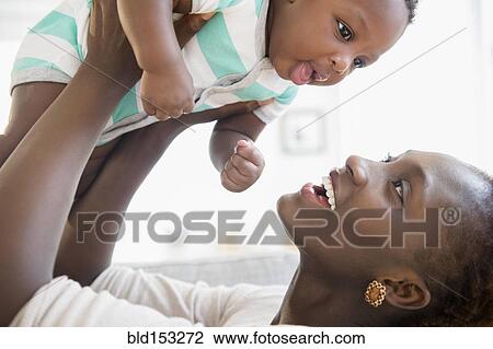 Black mother and son playing on sofa View Large Photo Image Stock Image - Black mother and son playing on sofa. Fotosearch