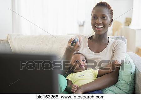Stock Photography - Black mother and son playing on sofa. Fotosearch