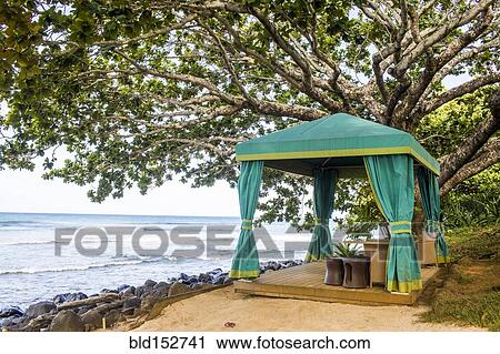 Stock Image - Cabana on sandy beach overlooking ocean. Fotosearch