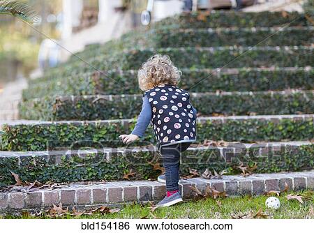 Stock Photograph - Caucasian baby boy climbing staircase. Fotosearch