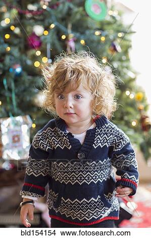 Picture - Caucasian baby boy decorating Christmas tree. Fotosearch