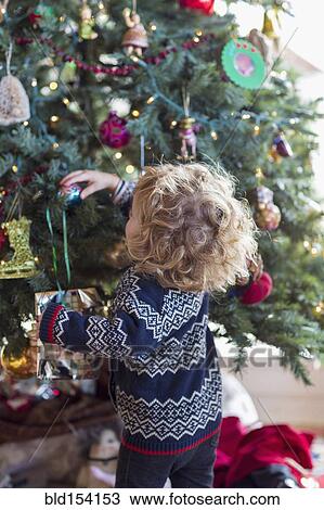 Caucasian baby boy decorating Christmas tree View Large Photo Image Stock Image - Caucasian baby boy decorating Christmas tree. Fotosearch