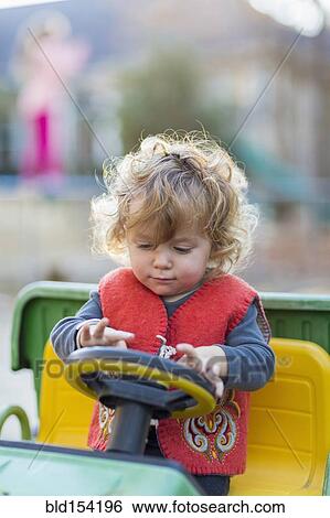 Stock Photograph - Caucasian baby boy driving toy tractor. Fotosearch