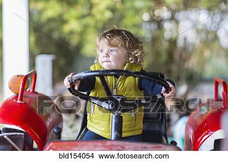 Picture - Caucasian baby boy driving tractor. Fotosearch
