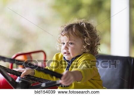 Stock Photo - Caucasian baby boy driving tractor. Fotosearch