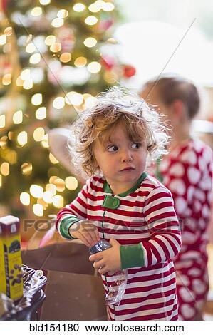 Caucasian baby boy opening present near Christmas tree View Large Photo Image Stock Image - Caucasian baby boy opening present near Christmas tree. Fotosearch