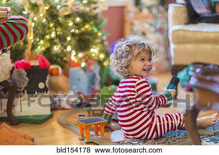 Caucasian baby boy opening presents near Christmas tree View Large Photo Image Stock Photo - Caucasian baby boy opening presents near Christmas tree. Fotosearch