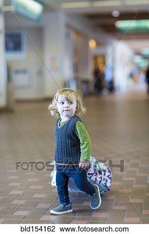 Caucasian baby boy rolling luggage in airport View Large Photo Image Stock Image - Caucasian baby boy rolling luggage in airport. Fotosearch