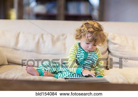 Caucasian baby boy using digital tablet on sofa View Large Photo Image Picture - Caucasian baby boy using digital tablet on sofa. Fotosearch