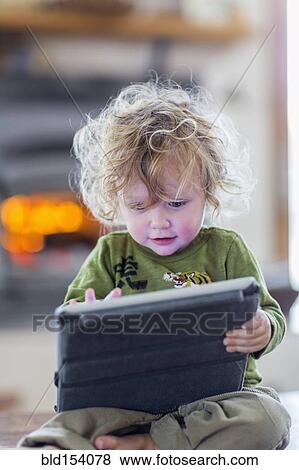 Stock Photo - Caucasian baby boy using digital tablet. Fotosearch