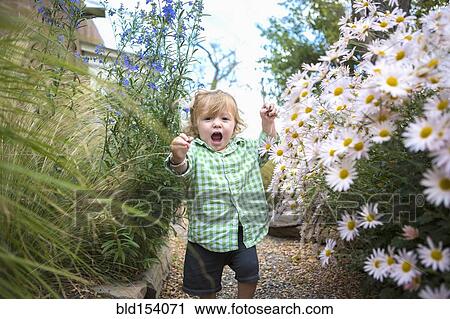 Stock Image - Caucasian baby boy walking in garden. Fotosearch
