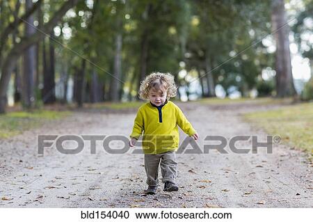 Caucasian baby boy walking on dirt road View Large Photo Image Stock Image - Caucasian baby boy walking on dirt road. Fotosearch
