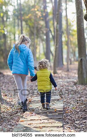 Caucasian brother and sister walking on wooden walkway View Large Photo Image Stock Photography - Caucasian brother and sister walking on wooden walkway. Fotosearch