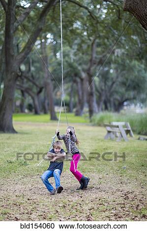 Caucasian children playing on swing in park View Large Photo Image Stock Image - Caucasian children playing on swing in park. Fotosearch
