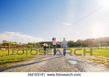 Caucasian children walking on dirt road on ranch View Large Photo Image Stock Image - Caucasian children walking on dirt road on ranch. Fotosearch