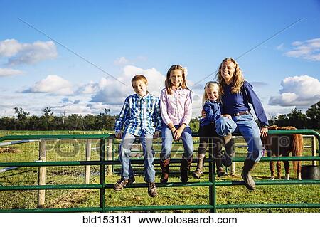 Caucasian farmer and children sitting on fence on ranch View Large Photo Image Stock Image - Caucasian farmer and children sitting on fence on ranch. Fotosearch