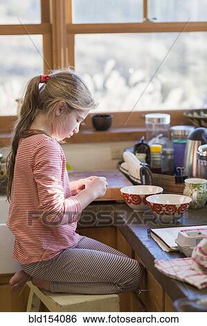 Stock Photograph - Caucasian girl cooking in kitchen. Fotosearch