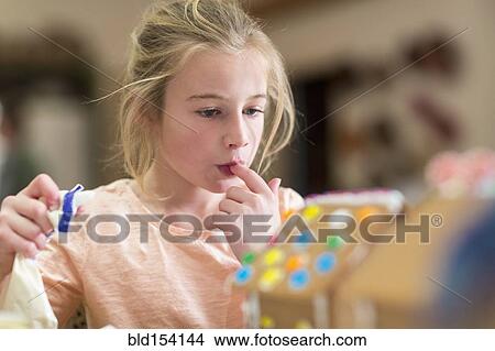 Caucasian girl decorating gingerbread house View Large Photo Image Picture - Caucasian girl decorating gingerbread house. Fotosearch
