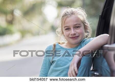 Stock Photo - Caucasian girl leaning on car. Fotosearch