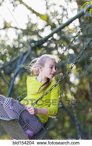 Picture - Caucasian girl sitting on swing. Fotosearch