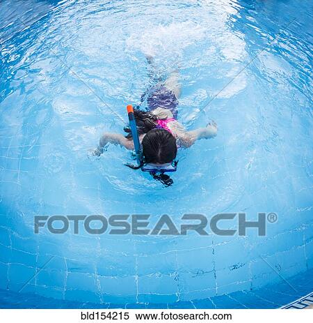 Stock Photography - Caucasian girl snorkeling in swimming pool. Fotosearch