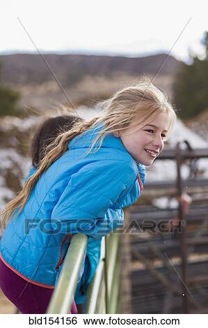 Caucasian girl standing on fence on farm View Large Photo Image Stock Photograph - Caucasian girl standing on fence on farm. Fotosearch