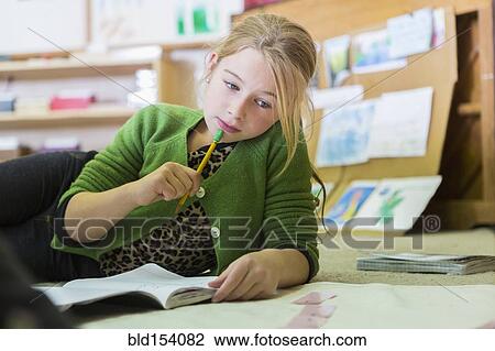 Stock Image - Caucasian girl working in classroom. Fotosearch