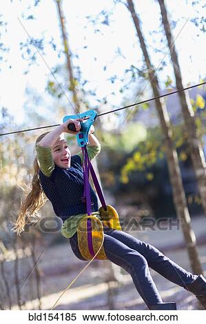 Caucasian girl zip lining in forest View Large Photo Image Stock Photography - Caucasian girl zip lining in forest. Fotosearch