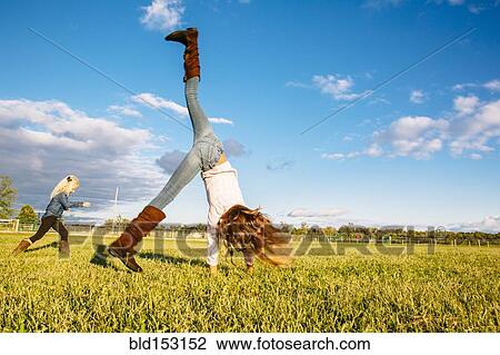 Caucasian girls playing in rural field View Large Photo Image Stock Image - Caucasian girls playing in rural field. Fotosearch