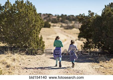 Caucasian girls walking on dirt path View Large Photo Image Stock Image - Caucasian girls walking on dirt path. Fotosearch