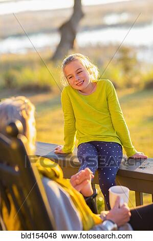 Caucasian grandmother and granddaughter relaxing on porch View Large Photo Image Stock Photo - Caucasian grandmother and granddaughter relaxing on porch. Fotosearch